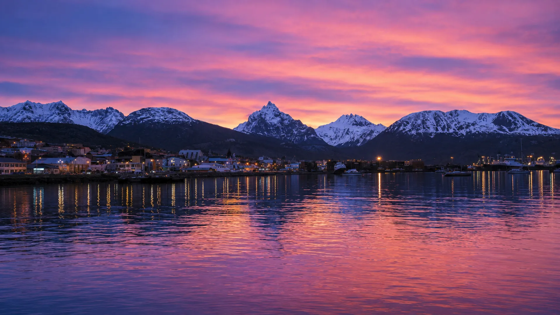 Ushuaia al atardecer sobre el Canal Beagle, con la cordillera Martial nevada al fondo